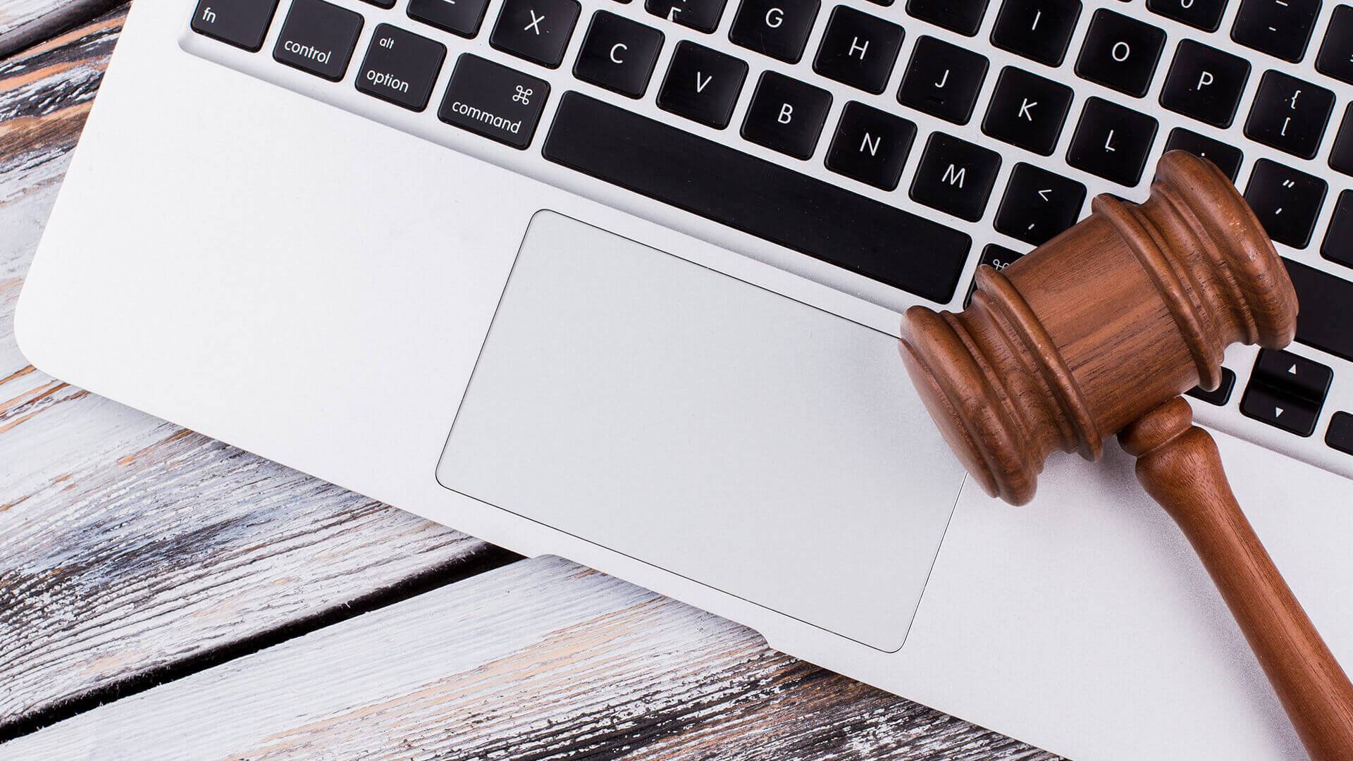 Laptop mit Holzhammer darauf