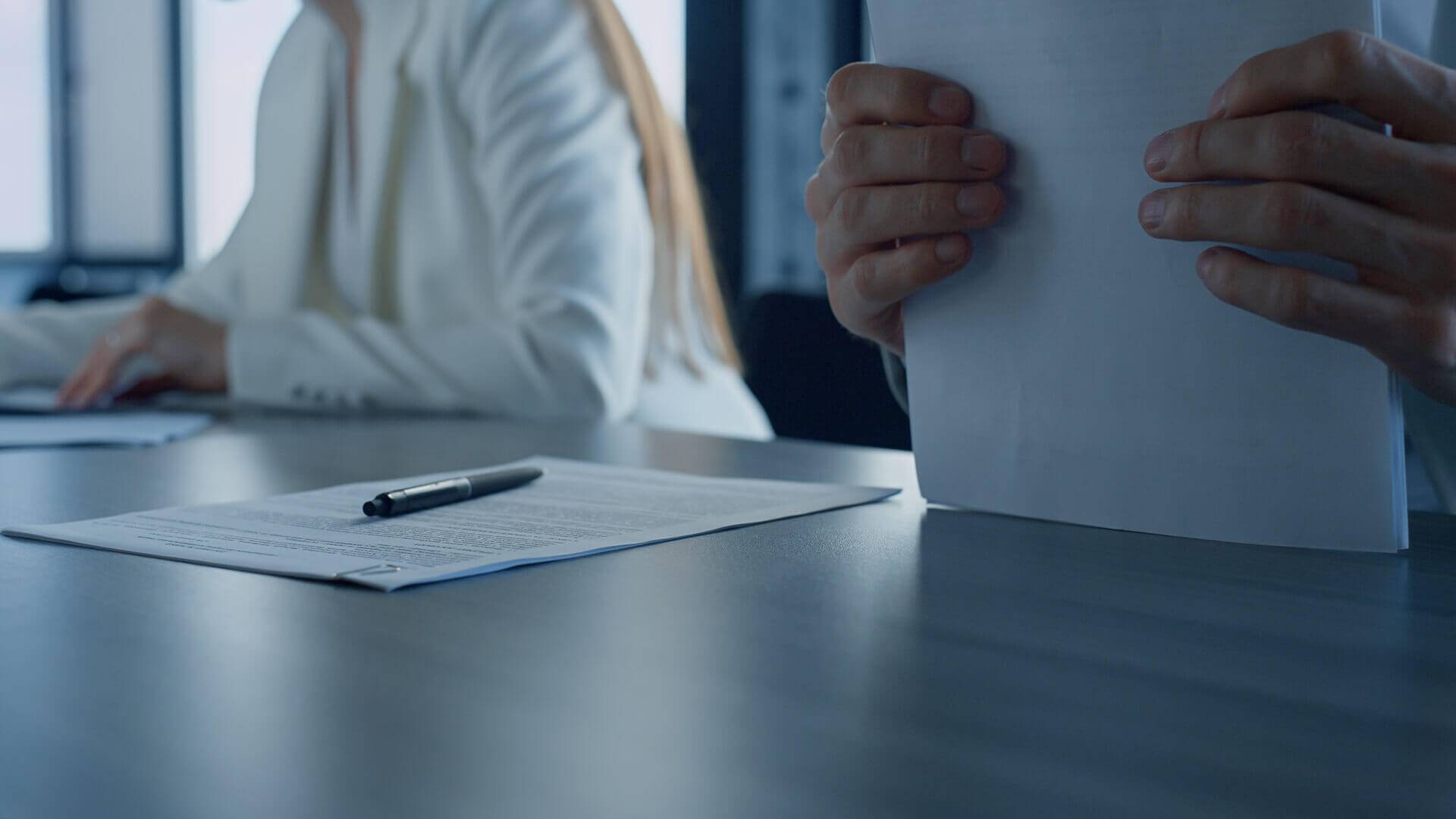 Person liest Buch am Tisch.