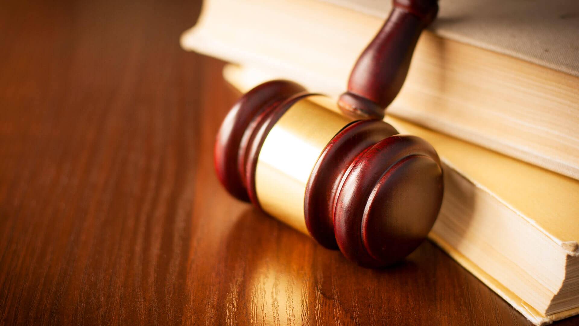 Holzhammer und Buch auf Tisch